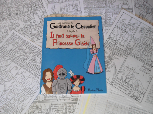 Le voici! Le tout premier album de Gontrand le Chevalier trône fièrement sur les dessins de quelques-unes de ses pages, et sur le cahier des croquis.